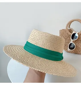 Close-up of a stylish woven straw sun hat with a vibrant green ribbon for summer beach trips.