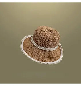 Close-up detailed view of hand-woven straw sun hat with elegant pearl trim decorations