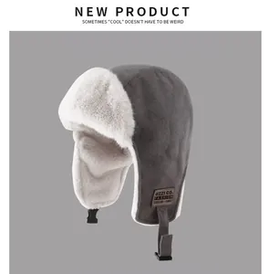 Close-up detail of a grey winter trapper hat with warm white faux fur lining and chin strap