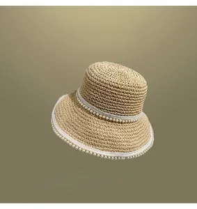 Detailed macro view of woven straw hat featuring elegant white pearl embellishments