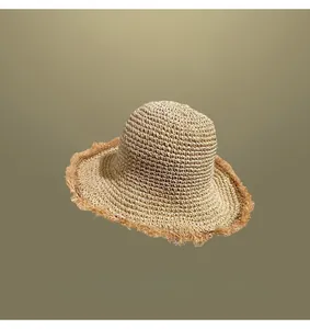 Close-up of hand-woven straw sun hat featuring a stylish frayed brim detail.