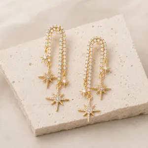 Detail of 18K gold plated long chain earrings featuring sparkling zircon star charms