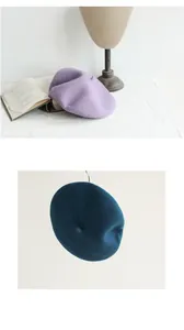Close-up detail of wool beret hats in purple and dark teal showing fine felt texture