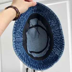 Detailansicht des schwarzen Schweißbandes und Kordelzugs in einem Denim-Fischerhut.