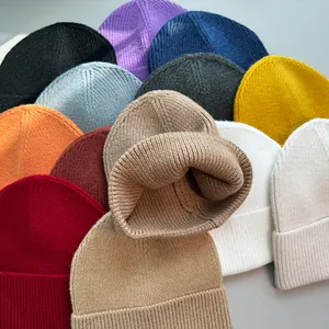 Detailansicht verschiedener bunter Strickmützen mit weicher Textur in vielen Farben