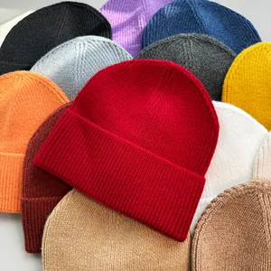 Detailansicht farbenfroher Strickmützen mit weichen Texturen und warmen Winterfarben.