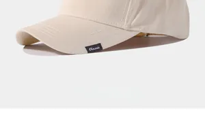 Primo piano del bordo di un berretto da baseball beige con etichetta Classic tessuta