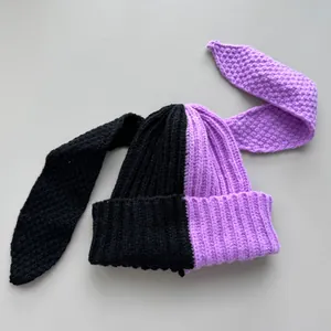 Detail view of a black and purple contrast color knitted beanie with long bunny ears