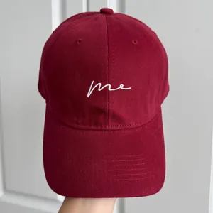 Vue détaillée d'une casquette de baseball bordeaux avec texte brodé blanc "me".