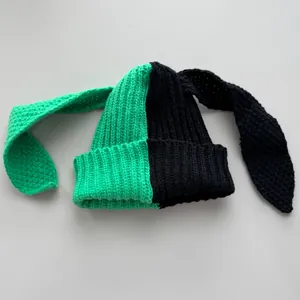 Close-up of green and black split-color knit beanie featuring long cartoon bunny ears.