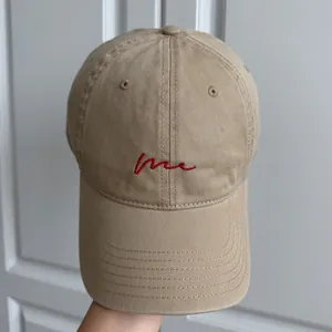Gros plan sur la broderie rouge 'me' d'une casquette de baseball en coton kaki détail