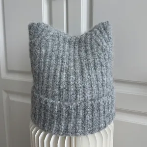 Detailed view of the grey knitted beanie with cute cat ears and fuzzy texture
