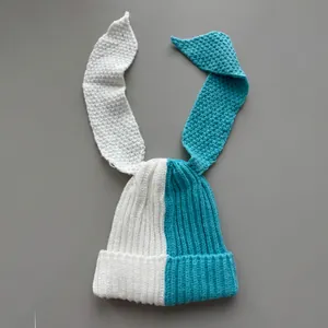Detail view of a two-tone knitted beanie with long rabbit ears in white and blue