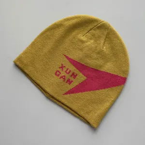 Primer plano detallado de un gorro de punto de invierno amarillo con gráfico rojo