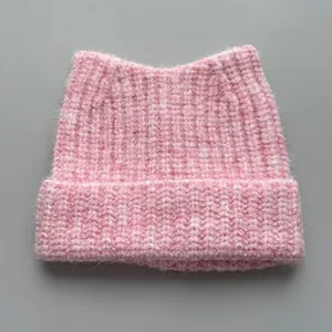 Macro view showing the soft knit texture and cute cat ear design of the pink beanie