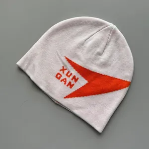 Primer plano detallado de la textura de punto suave y el gráfico naranja del gorro rosa.