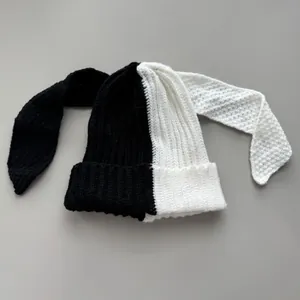 Close-up of two-tone knitted beanie with long bunny ears in black and white finish