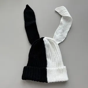 Close-up view of the black and white split knit beanie featuring long rabbit ears
