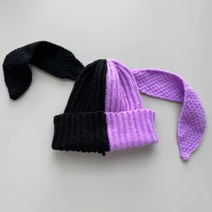 Detailed view of two-tone purple and black knit beanie featuring extra long floppy bunny ears