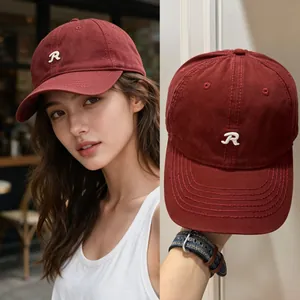 Détail rapproché d'une casquette de baseball rouge foncé avec logo R blanc brodé élégant