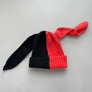 Detail view showing texture of black and red split color knitted bunny ear beanie