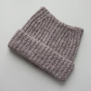 Detailed close-up showing the soft ribbed texture of a mauve cat-ear knitted beanie hat