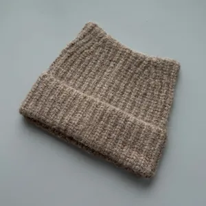 Close-up view of a brown ribbed knitted beanie with cat ear design for winter