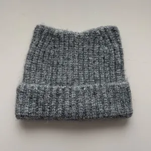 Detailed macro view of a grey cat ear knitted beanie showing soft fuzzy wool texture