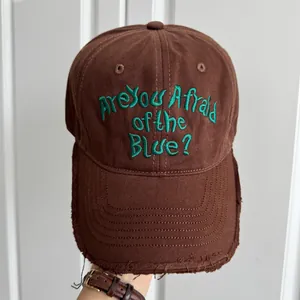Détail d'une casquette marron avec broderie verte 'Are You Afraid of the Blue?'