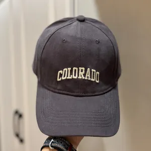 Détail en gros plan de la broderie crème 'COLORADO' sur une casquette de baseball gris foncé