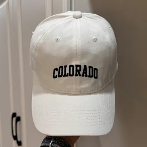 Vue détaillée d'une casquette de baseball crème avec texte Colorado brodé noir
