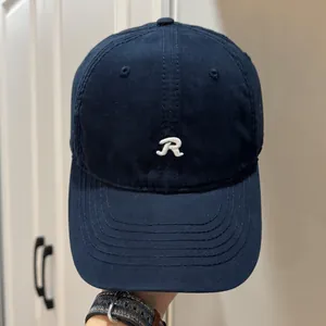 Vue détaillée de face d'une casquette de baseball bleu marine avec la lettre R brodée