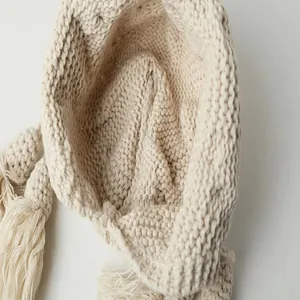 Detailansicht der handgemachten groben Stricktextur dieser beigen Ohrenklappenmütze