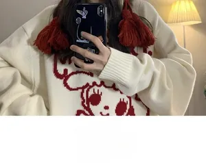 Detailansicht einer festlichen roten handgestrickten Wintermütze für Damen mit Quasten.