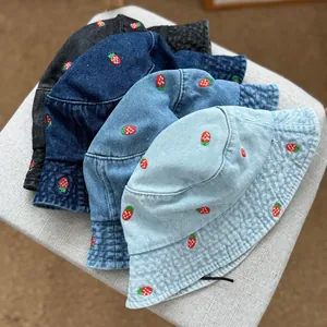 Detailed view of four colors of strawberry embroidered denim bucket hats for summer