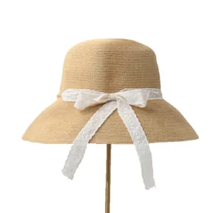 Elegant women's straw sun hat with wide brim and white lace bow detail