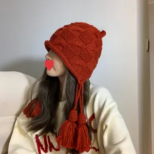 Handgestrickte rote Beanie mit Quasten und Ohrenschutz für wohlige Winterwärme