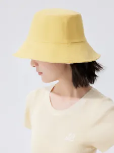 Side profile detail of a woman wearing a wide-brimmed bright yellow summer bucket hat