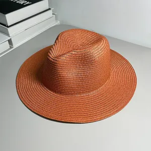 Detail view of the fine woven texture on a stylish orange Panama sun hat for beach