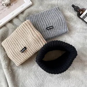 Dettaglio di tre fasce in maglia nei colori grigio, beige e nero con etichette logo.