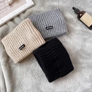 Vista dettagliata delle fasce in maglia calde in beige, grigio e nero per l'inverno.