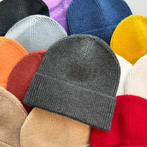 Detailansicht verschiedener einfarbiger, warmer Strickmützen in diversen Farben.