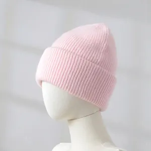 Close-up detail of soft pink rabbit hair knitted beanie hat shown on a white mannequin head