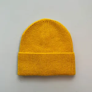 Detailaufnahme der gelben Strickmütze mit weicher Textur aus Imitat-Kaschmirgewebe.