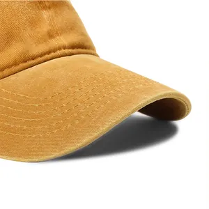 Macro view of a washed yellow cotton baseball cap brim showcasing detailed stitching
