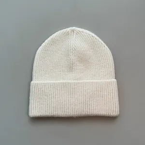 Weiche cremeweiße Strickmütze aus Kaschmirimitat mit klarem, minimalistischem Design.