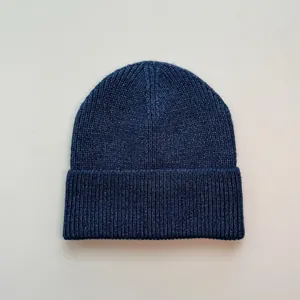 Nahaufnahme einer klassischen marineblauen Rippstrick-Beaniemütze für Winterwärme.