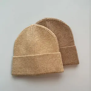 Detailansicht von zwei warmen Rippstrick-Beanie-Mützen in Braun und Beige für den Winter