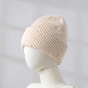Close-up of beige rabbit hair knitted beanie on mannequin head, showing soft texture.