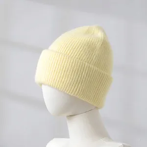 Close-up of pale yellow rabbit fur knit beanie showing thick warm ribbed texture
